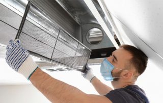 This image shows a man cleaning an airduct.