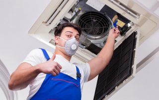 This image shows a man cleaning an airduct.