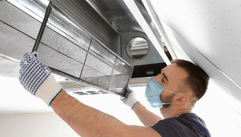 This image shows a man cleaning an airduct.