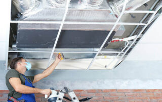 This image shows a man cleaning an air duct.